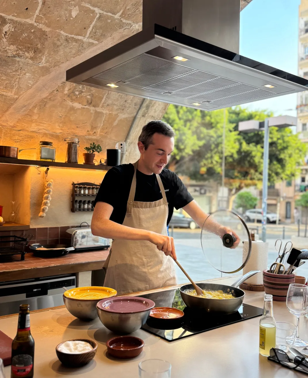 Julian steht in einer offenen Küche und kocht konzentriert. Ein Blick hinter die Kulissen, der zeigt, dass er nicht nur im Code, sondern auch am Herd mit seinem Team kreativ ist.